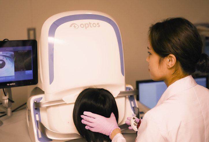 機器を使って患者の目の検査をする女性の視能訓練士