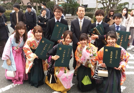 卒業する学生に囲まれて写真に写る川野庸一先生